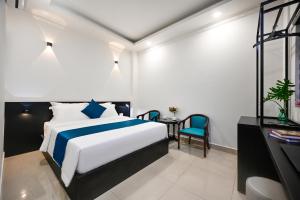 a bedroom with a bed and a table and a chair at Trung Mai Hotel - Nguyễn Thái Bình in Ho Chi Minh City
