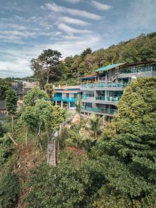 an apartment building on top of a hill with trees at Cliff Lanta Suite-Koh Lanta Krabi in Ko Lanta