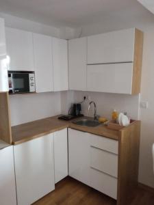 a kitchen with white cabinets and a sink at Vila Barselona Kopaonik in Raška