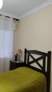 a bedroom with a bed with a yellow blanket at El respiro de la Vera AT-CC-00876 in Jarandilla de la Vera