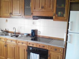 a kitchen with wooden cabinets and a sink at El respiro de la Vera AT-CC-00876 in Jarandilla de la Vera