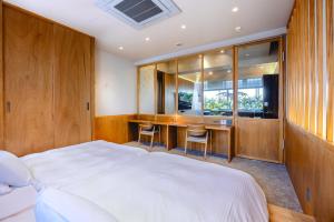 a bedroom with a bed and a desk with chairs at YUURO Bath-Living Hotel Ryogoku in Tokyo +25 photos