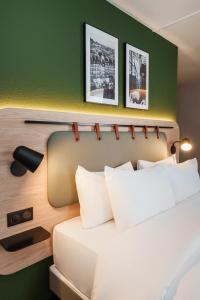a bedroom with a bed and a green wall at Campanile PRIME - Nice Airport in Nice
