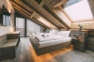a bedroom with a large bed with a large window at LIVALPIN Chalet - with private Sauna & Whirlpool in Garmisch-Partenkirchen