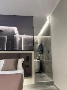 una camera da letto con un letto e un bagno con un lavandino di Karma6Rooms - in Sicilia nel centro di Catania a Catania
