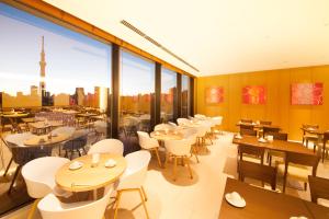 um restaurante com mesas e cadeiras e vista para a cidade em Richmond Hotel Premier Asakusa International em Tóquio