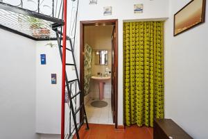 a bathroom with a yellow shower curtain and a ladder at Refúgio, casa típica Portuguesa in Setúbal +23 photos