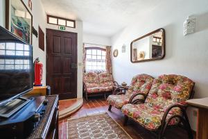 a living room with two chairs and a mirror at Refúgio, casa típica Portuguesa in Setúbal