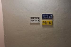 dos señales en el costado de una pared en BnB98 Silom Hotel, en Bangkok