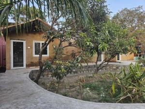 a house with a tree in front of it at The Ashok Vatika Farms and Stay in Haridwār