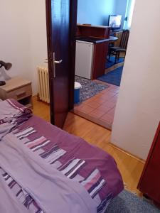 a room with a bed and a door leading to an office at Tina in Jahorina