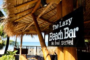 a sign on the side of a beach bar at The Lazy Lodge in Ko Lanta