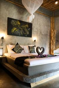 a bedroom with a large bed with a swan on it at The Lazy Lodge in Ko Lanta