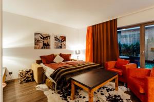 sypialnia z łóżkiem, krzesłem i oknem w obiekcie Residenz HÄNSEL by MoniCare w mieście Seefeld in Tirol