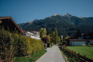 ścieżka prowadząca do domu z górami w tle w obiekcie Chalet SOLYMONT by MoniCare w mieście Seefeld in Tirol
