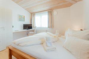 białe łóżko w pokoju z oknem w obiekcie Chalet SOLYMONT by MoniCare w mieście Seefeld in Tirol