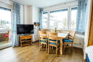 jadalnia ze stołem, krzesłami i telewizorem w obiekcie Appartement Amalie by MoniCare w mieście Seefeld in Tirol