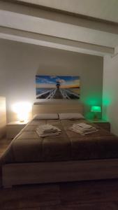 een slaapkamer met een groot bed met een schilderij aan de muur bij Alle Volte Maison in Grumo Appula