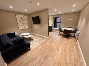 una sala de estar con un sofá y una mesa en 2 BR Ensuite Leeds, en Central Station