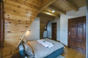 a bed in a room with a wooden wall at Bajin chalets in Dobroselica