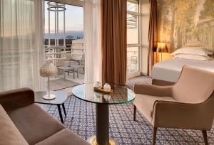 a junior suite with a bed and a living room at Célestins Spa Thermal & Hôtel by Vy Resort in Vichy