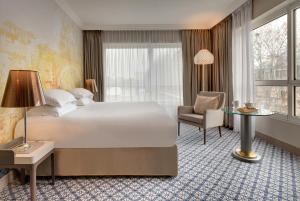 a hotel room with a bed and a desk and a chair at Célestins Spa Thermal & Hôtel by Vy Resort in Vichy