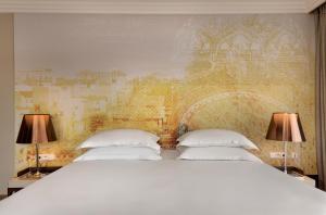 a bedroom with a large bed with two lamps at Célestins Spa Thermal & Hôtel by Vy Resort in Vichy