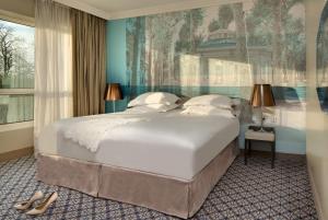 a bedroom with a large bed with a painting on the wall at Célestins Spa Thermal & Hôtel by Vy Resort in Vichy +56 photos
