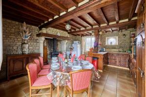 a dining room with a table and chairs in a kitchen at La Maison de Lallier - à 35 min de Cherbourg in Turqueville