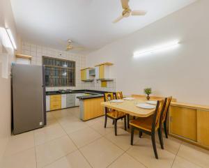 a kitchen with a table and chairs and a refrigerator at Giriraj Homestay 3 BHK with Driver Room in Kolhapur