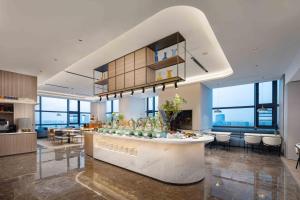 a lobby with a bar in a building with windows at Holiday Inn Express Wuhan East Lake by IHG in Wuhan +63 photos