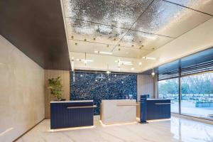 武漢市にあるHoliday Inn Express Wuhan East Lake by IHGの青いカウンターと大きな窓が備わるロビー