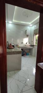 een keuken met witte tegelvloeren en een aanrecht bij Taghazoute surf home in Taghazout +1 foto