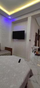 een kamer met een bed en een televisie aan de muur bij Taghazoute surf home in Taghazout