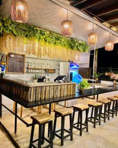 un restaurant avec un bar doté de bancs et de lumières dans l'établissement Mai Resort Hotel, à Laoac