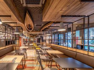 restauracja ze stołami, krzesłami i oknami w obiekcie ibis Styles Warszawa Centrum w Warszawie