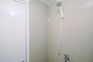 a shower with a shower head in a bathroom at Cozy and Simply Studio at Bogorienze near The Jungle Apartment By Travelio in Pamoyanan +12 photos