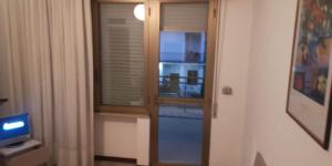 Habitación con ventana y puerta con TV. en LOCRI SUITE più CAMERE, en Locri