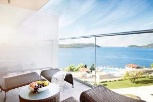 a room with a balcony with a view of the ocean at Sun Gardens Dubrovnik in Dubrovnik