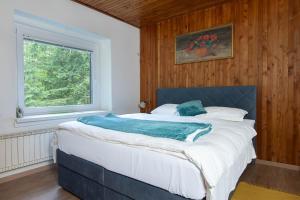 a bedroom with a large bed with a window at House Angelca in Hočko Pohorje
