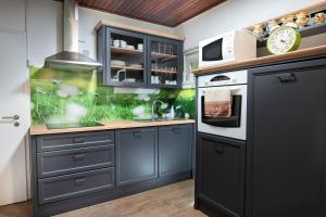 a kitchen with blue cabinets and a stove top oven at House Angelca in Hočko Pohorje