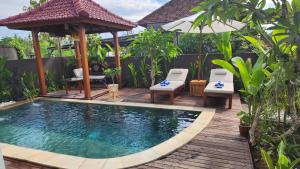 una piscina con cenador y sillas en una terraza en Gp House Bali, en Gianyar