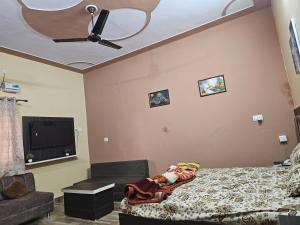 a bedroom with a bed and a ceiling fan at The Ashok Vatika Farms and Stay in Haridwār