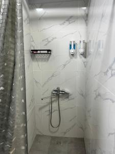 a bathroom with a shower and a shower curtain at Samal Hostel in Gornyy Gigant