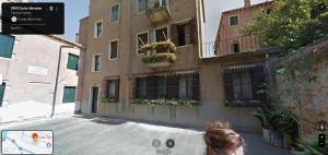 a woman is standing in front of a building at Casa Alimante in Venice