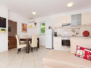 a kitchen and living room with a table and a couch at Apartments Josip in Čižići