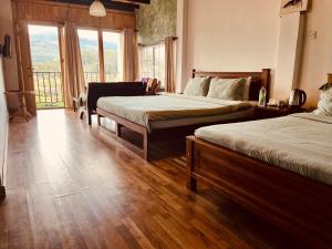una camera d'albergo con due letti e una grande finestra di Medalin Lake Gregory a Nuwara Eliya