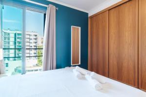 a bedroom with a bed and a large window at GuestReady - Sea breeze in Funchal in Funchal +83 photos
