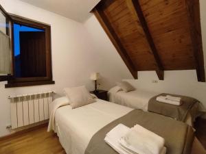 una camera da letto con due letti e una finestra di Homenfun Baqueira Beret Vielha III a Betrén