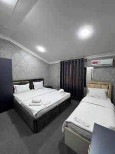 two beds in a hotel room with two bedsvisor at Lotus Hotel in Yakkasaray +17 photos